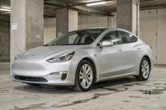 Véhicule électrique moderne vieillissant garé dans un parking urbain en béton, illustrant la durabilité à long terme d'une voiture électrique